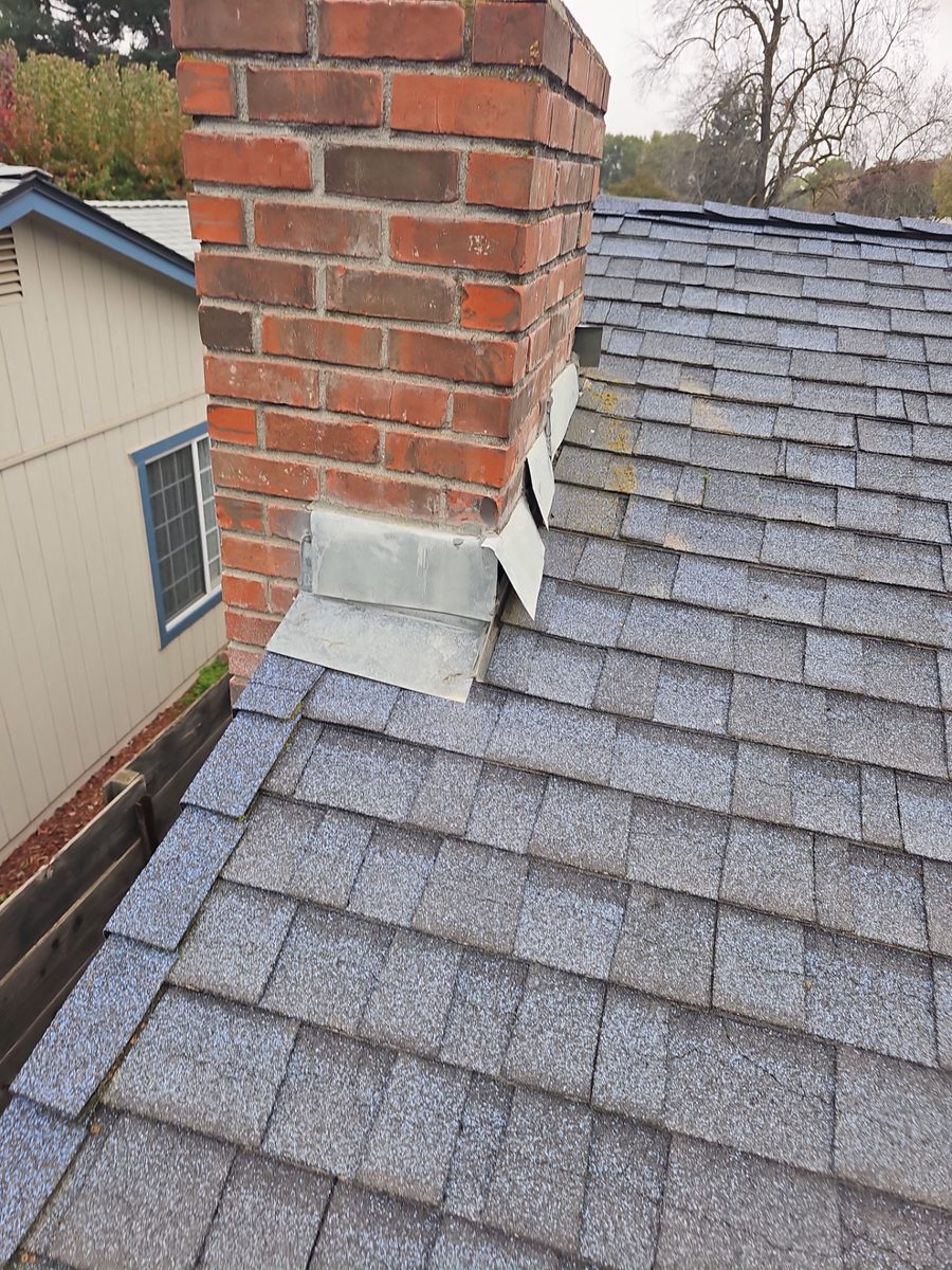 Failed brick chimney flashings on the Atwater home before roof replacement