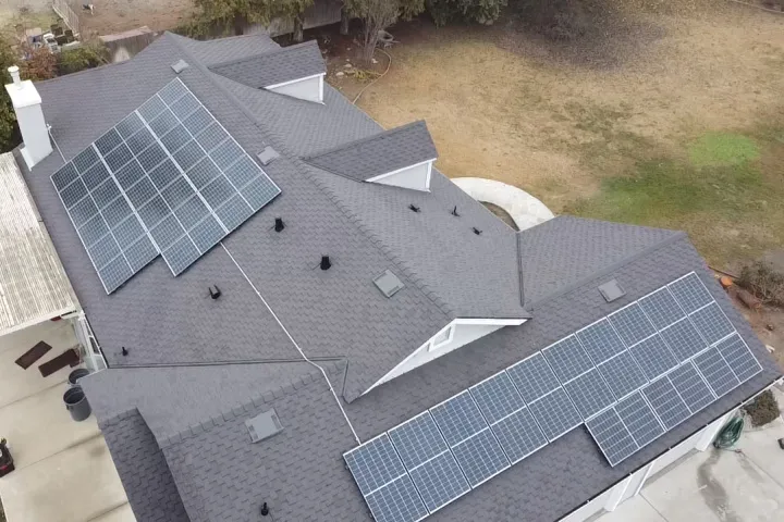 Aerial view of the completed architectural shingle roof with rooftop solar arrays in Modesto, CA