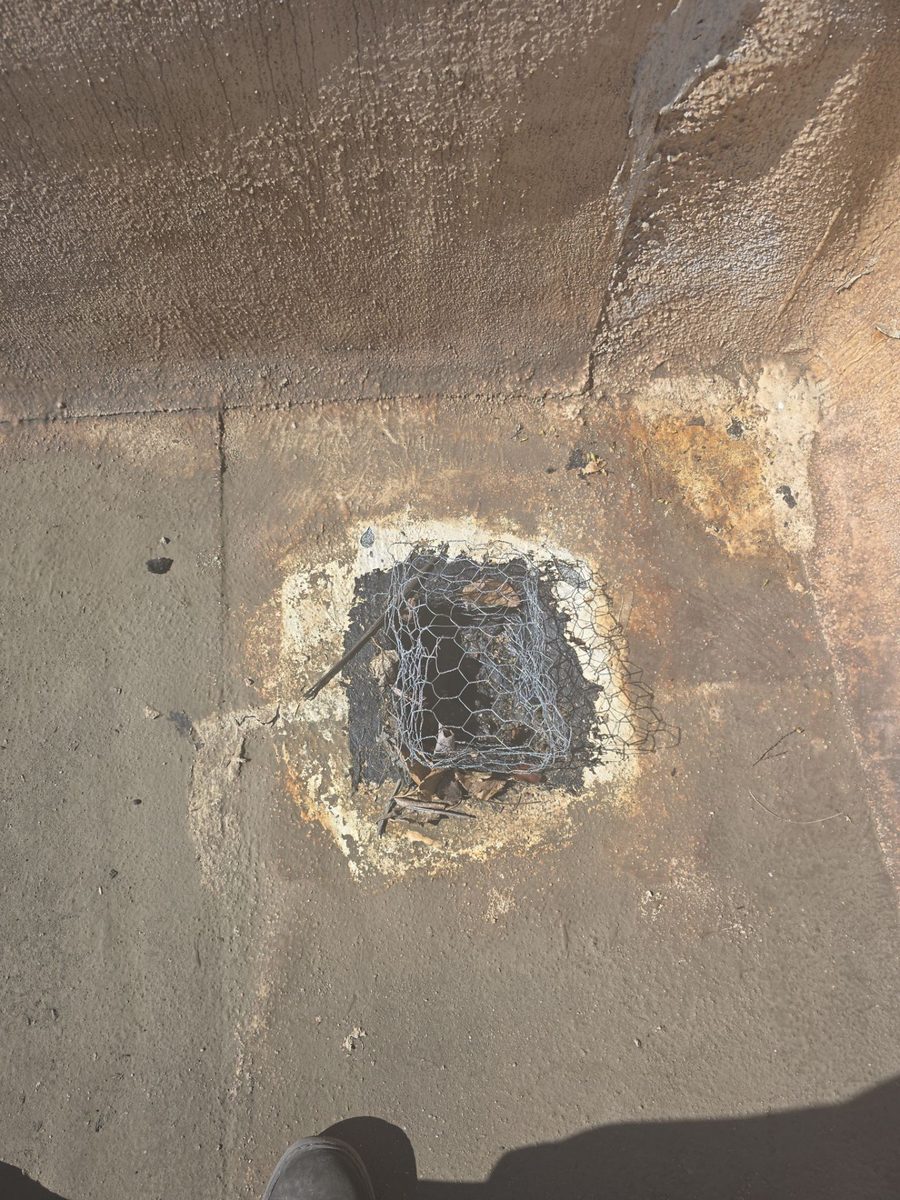Failed rooftop drain with exposed reinforcement on a Modesto flat roof before repair