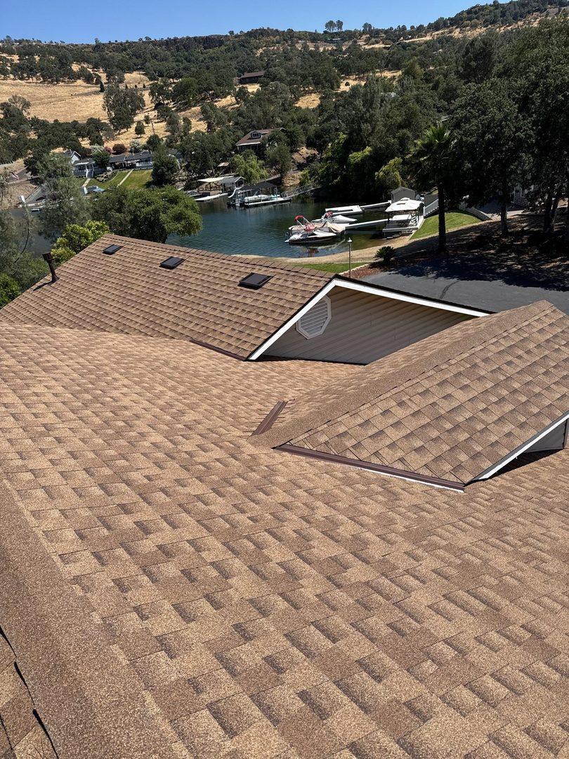 Completed roof replacement on lakefront home in Jamestown, CA with lake and boat dock in background