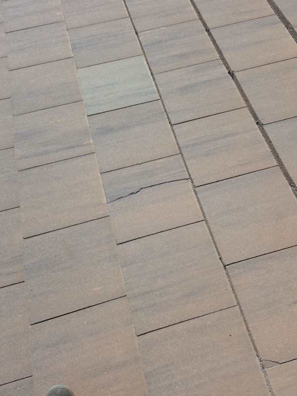 Cracked concrete tile with visible leak point on Livingston roof
