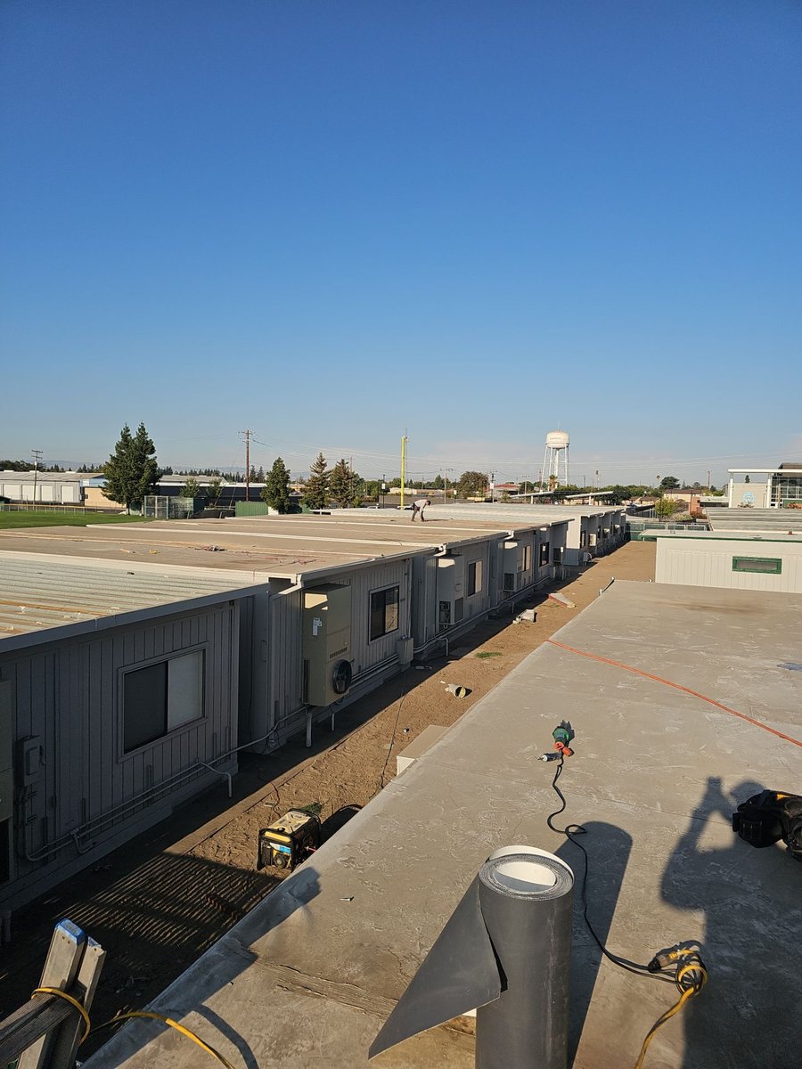 TPO commercial roofing at Manteca High School with HVAC units and campus buildings
