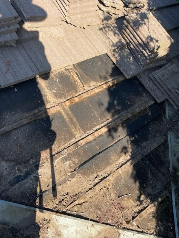 Riverbank tile roof before repair — cracked and displaced roof tiles