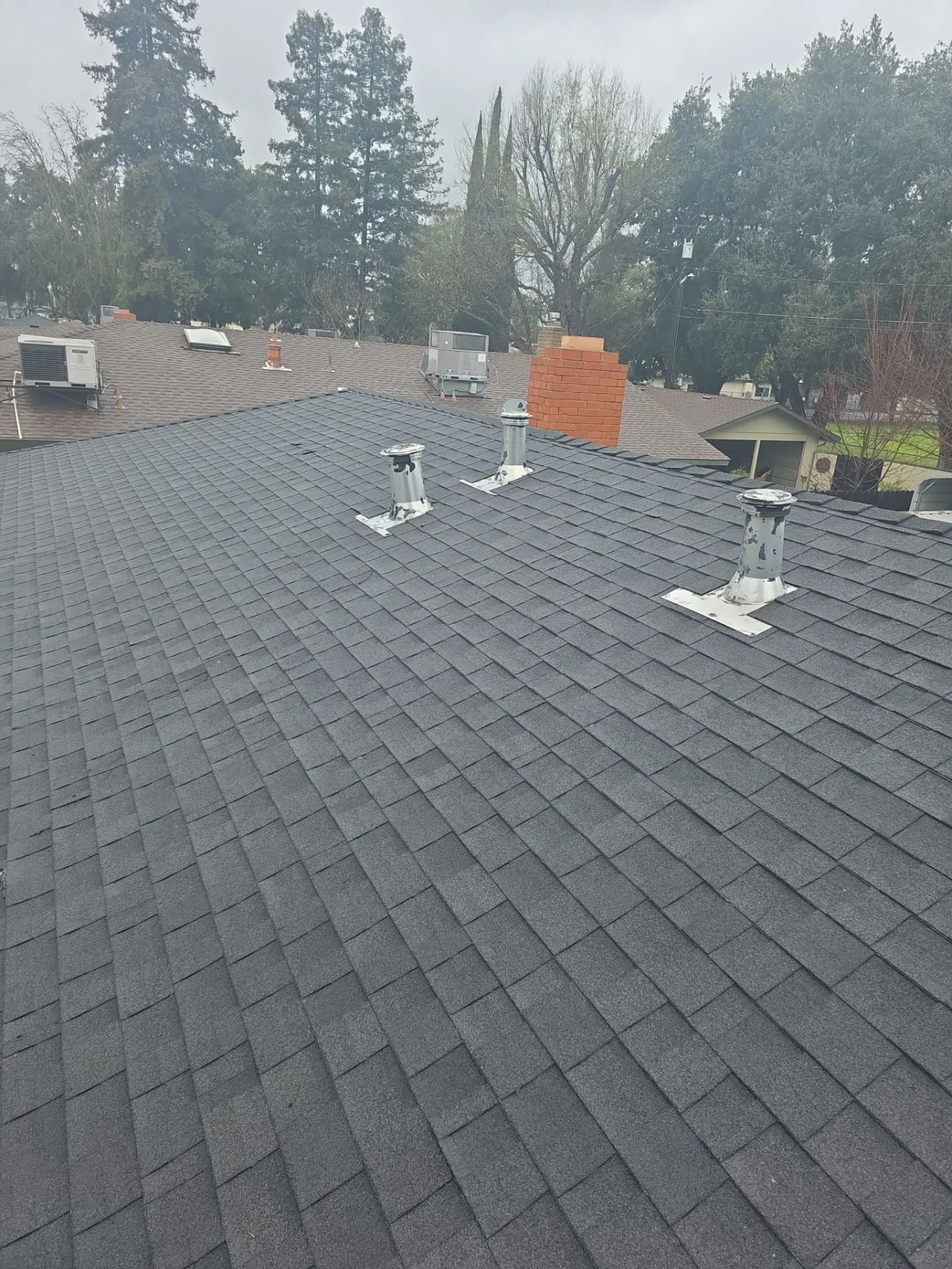 Turlock Charles Pl home after full tear-off and re-roof — aerial view of the finished new roof