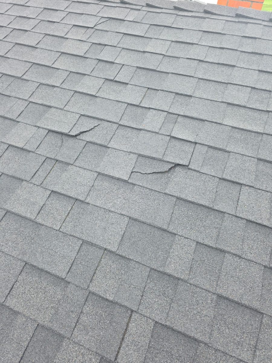 Cracked and lifted composition shingles on the Turlock home before replacement