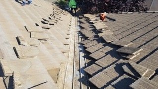 Tile roof tear-off in progress — Econo Roofing crew removing concrete tile from a Central Valley residential home, showing roof structure and underlayment.